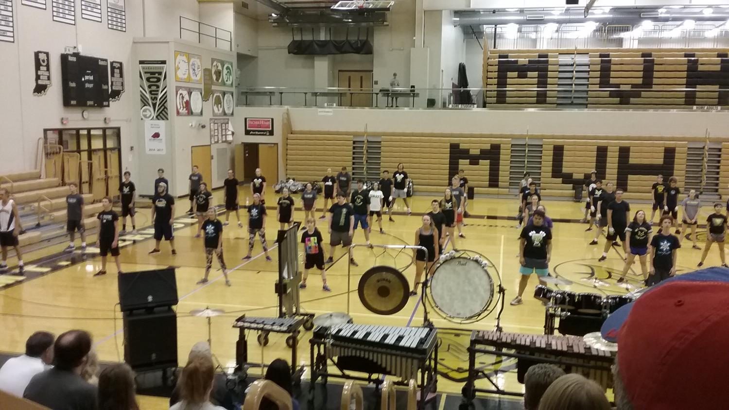 The marching band practicing in the gym