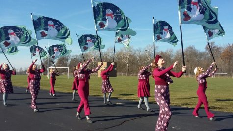 the color guard members are waving flags with snowmen on them.