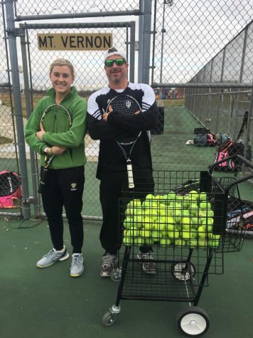 Two coaches stand for a picture with their rackets in hand.