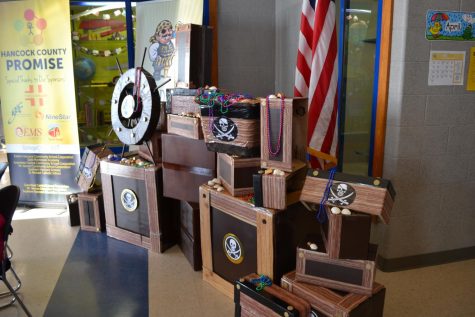 A stack of treasure box decorations sit in the school hallway.