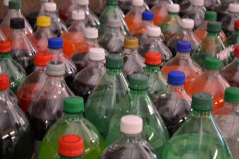 Many 2-liter bottles of soda are lined up together.