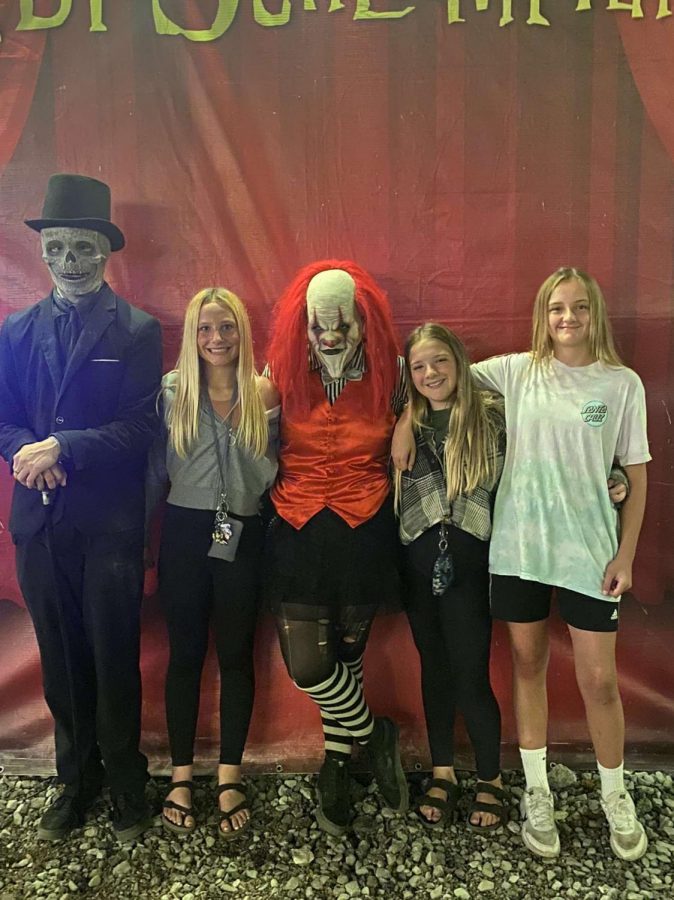 A group poses with Icky the Clown and Sugar Skull