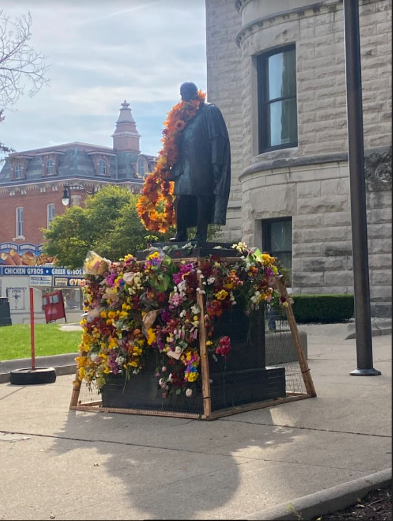 Statue of James Whitcomb Riley covered in flowers