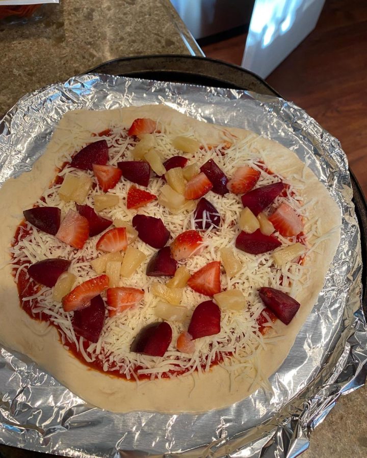 Pizza with plums, strawberries, and pineapple chunks.
