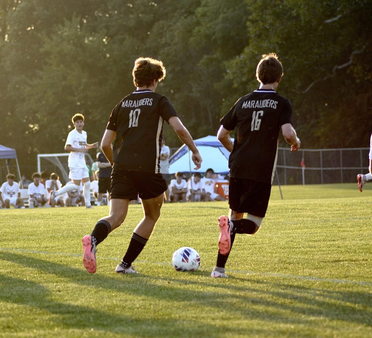 Number 10, Brady Webber (11), and number 16, Drew Lynch (12) advancing the ball down the field. 
