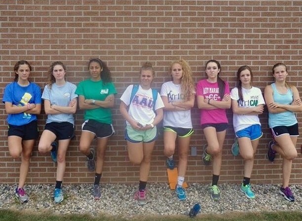 Girl Soccer players leaning against a brick wall