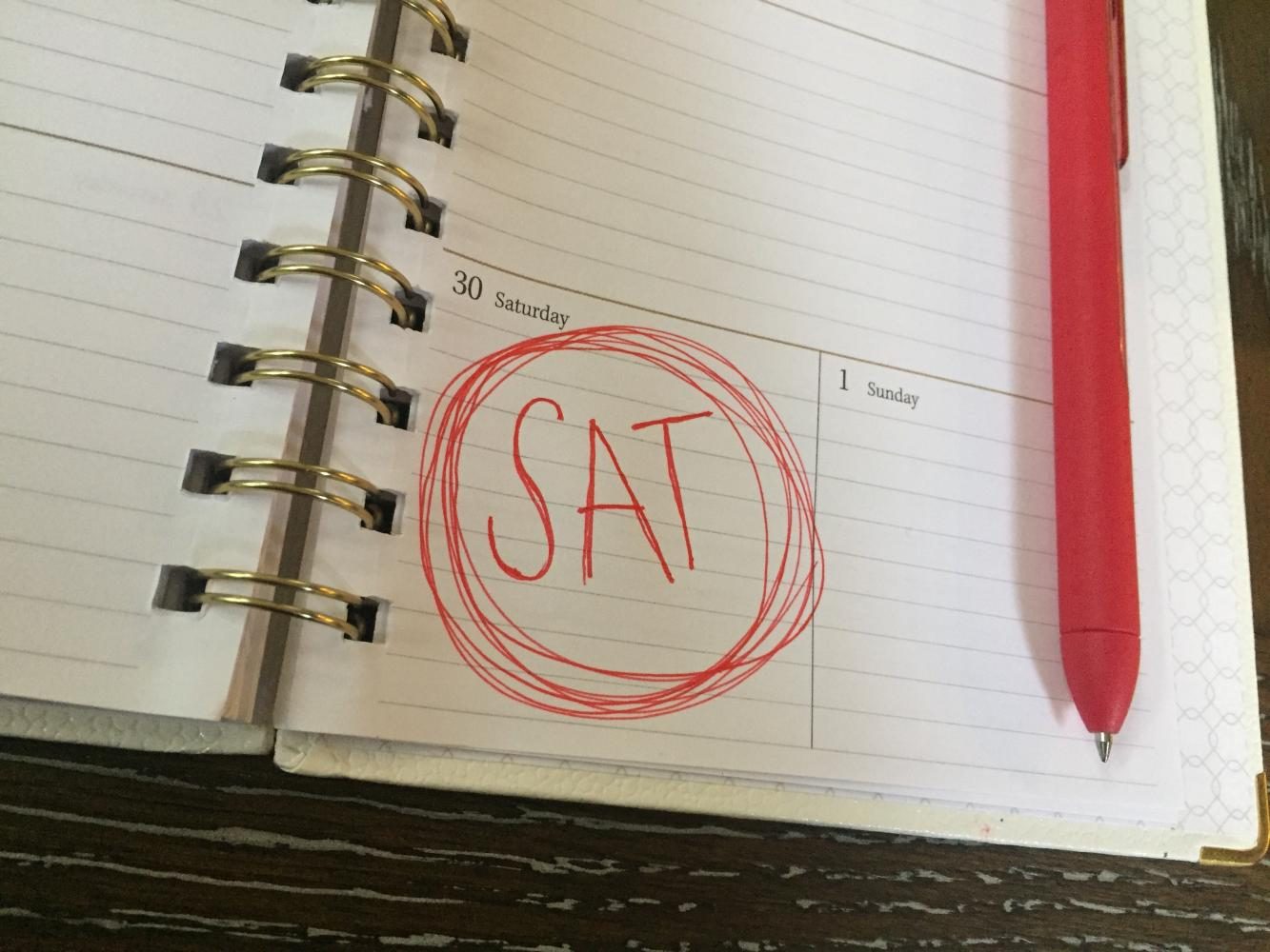 SAT written in red ink on a calendar that says Saturday 30