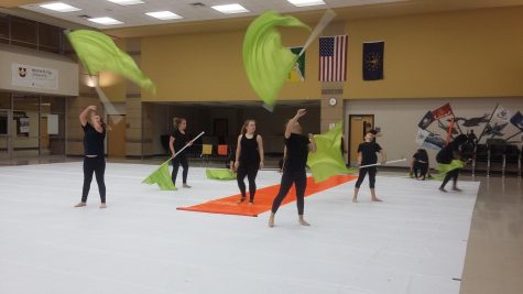 multiple guard members twirl their flags