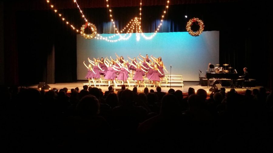 The Expressions choir members dance onstage while performing.