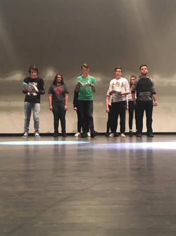 5 students with scripts stand on stage.