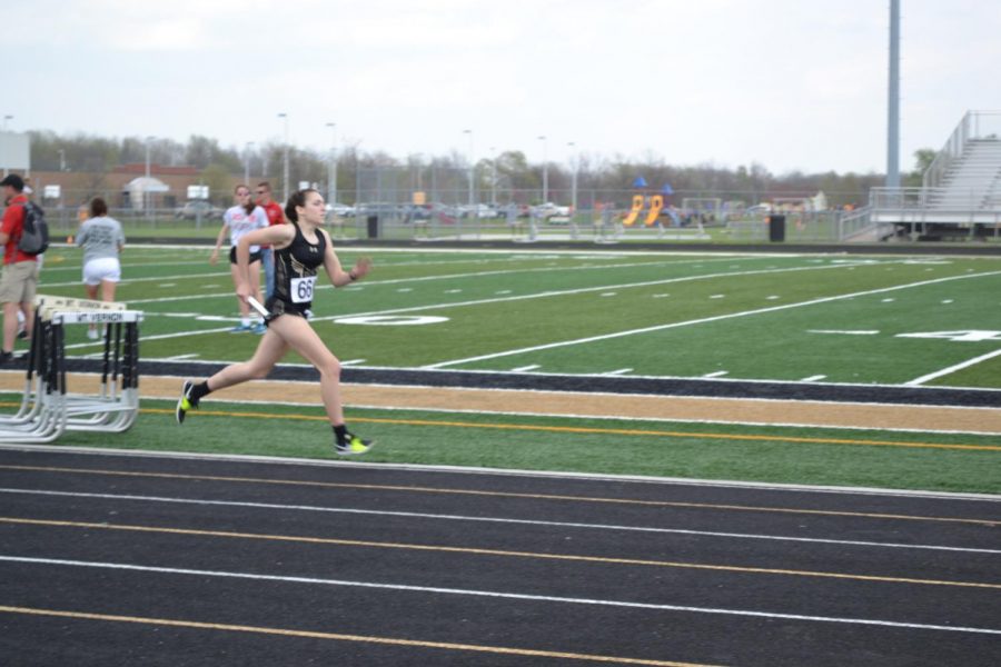 A girl is running on the track, and she is not around anyone else.