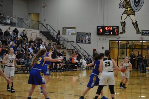 One of the players has the ball and is running toward the net. 