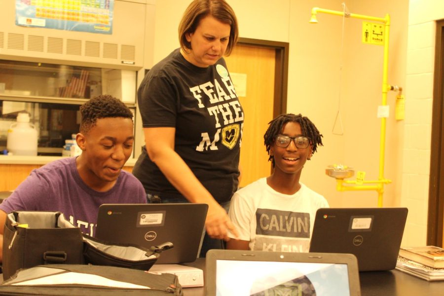 Mrs. Wilson helping Jalen Davidson and Mj Warren with the writing station.  
