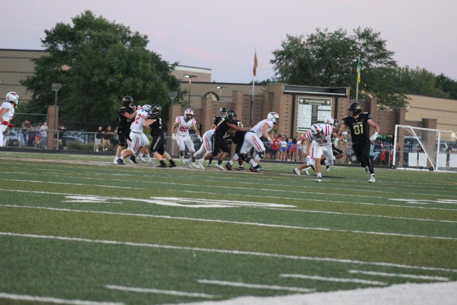 Player 81, George Burnhenn (12), ready to catch the ball, in his role as an offensive player. 
