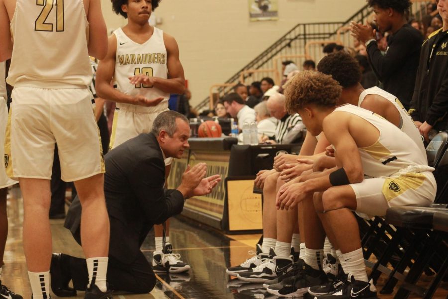 The team discusses the next play during time out called by the Marauders at a score of 12- 14 against Lawrence Central in the lead. 
